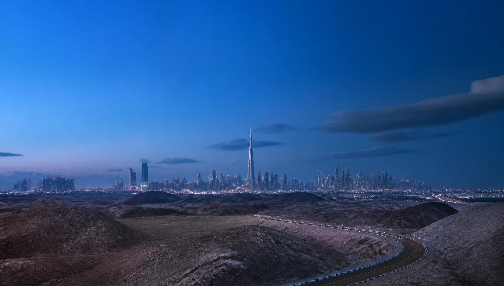 Dubai skyline beyond desert ridges at blue hour